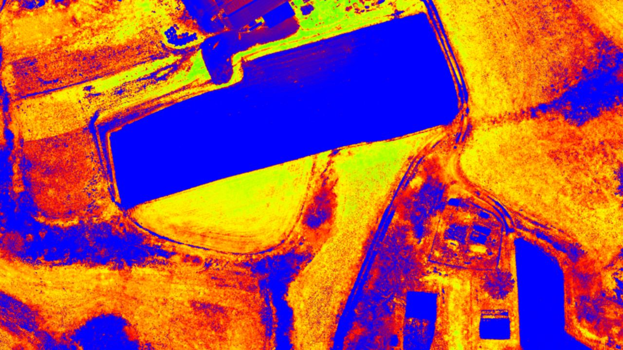 Soil adjusted vegetation index in false colours, with fields, wheel tracks, hedges and a water surface