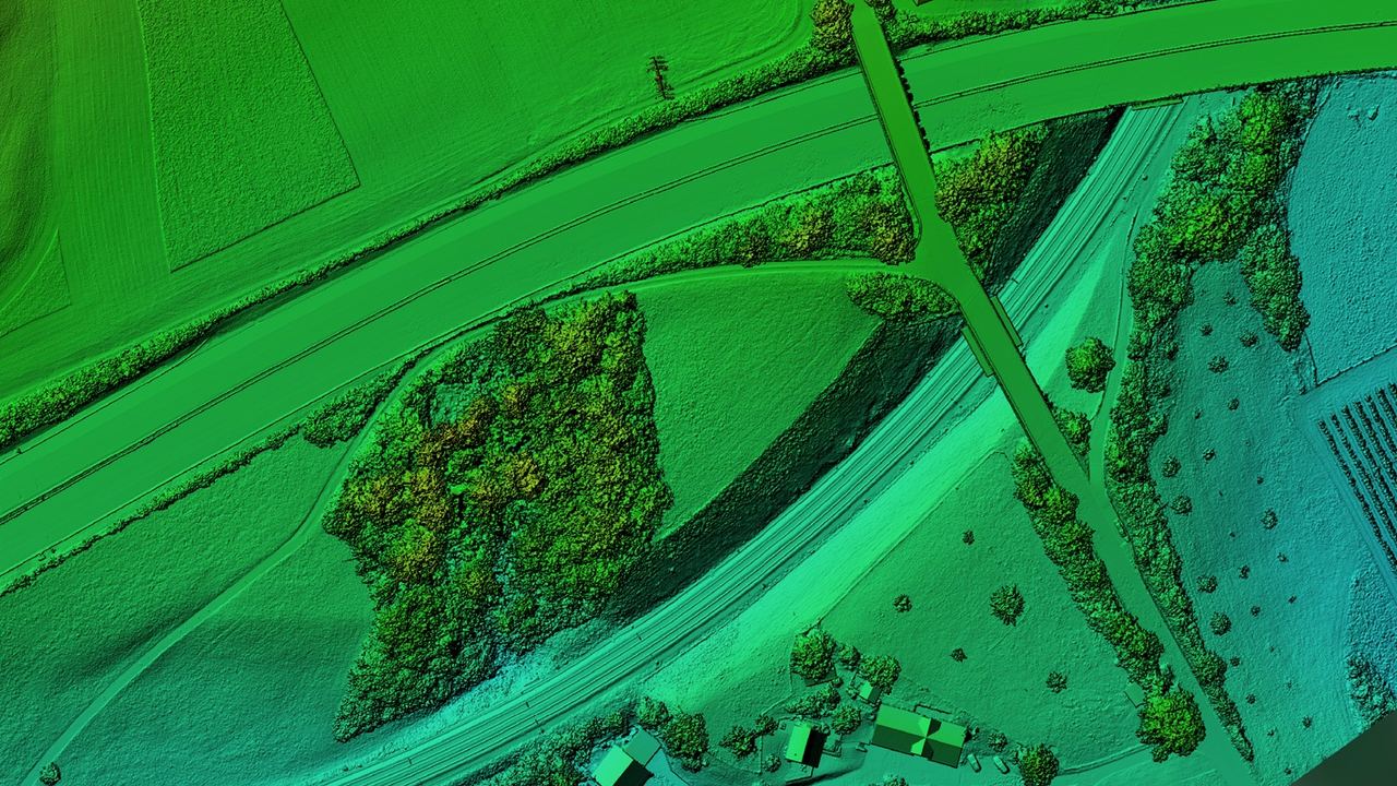 Oberflächenmodell in Grüntönen mit Schummerung, mit einer Strasse, einer Freileitung, Feldern und einem Waldrand