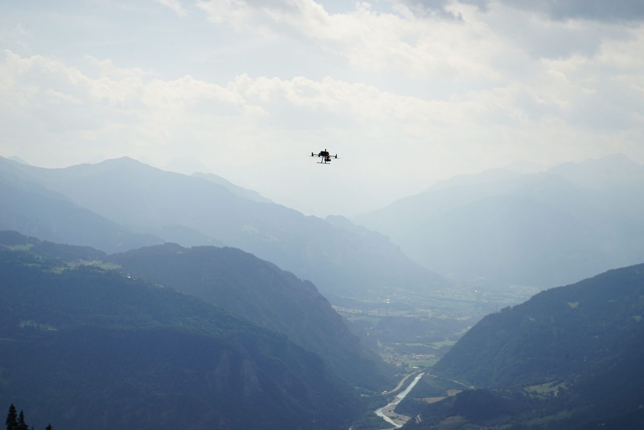Luftaufnahme einer Schweizer Landschaft mit Siedlung und Verkehrsweg