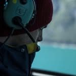 Urs Clement wearing a headset in the helicopter cockpit