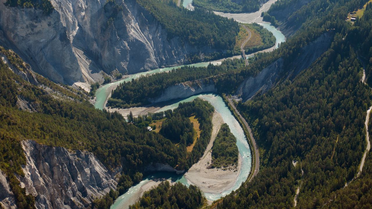 Die Rheinschlucht aus der Luft, der Rhein zieht Schleifen zwischen Kiesbänken, Wald und hellen Felswänden